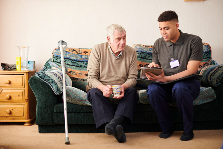 helping elderly man with tablet